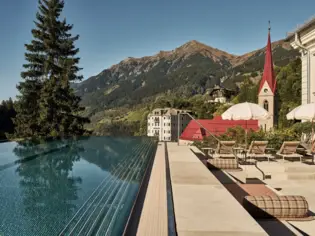 Pool mit rotem Kirchturm und Berg im Hintergrund.