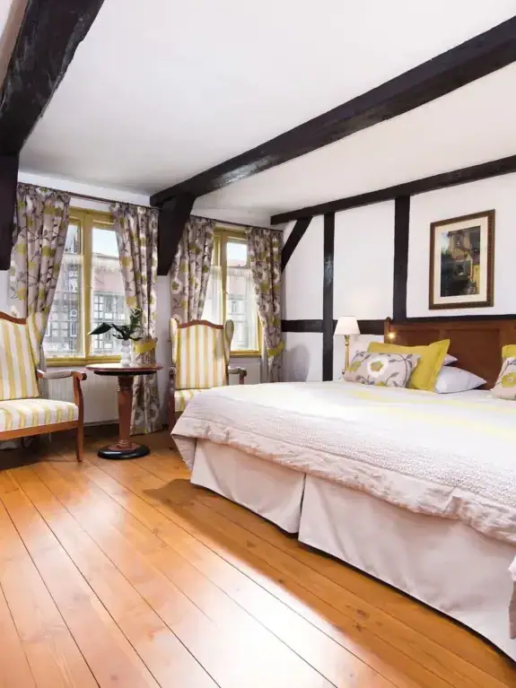 Ein Zimmer mit einem Bett und Stühlen.