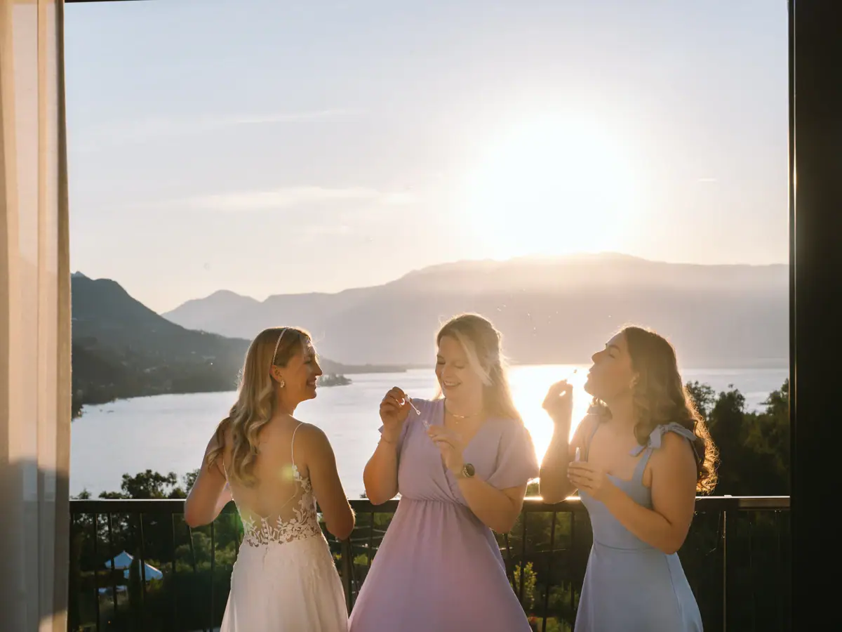 Braut und Brautjungfern im A-ROSA Gardasee Eine Gruppe von Frauen in festlichen Kleidern, die Seifenblasen pusten.
