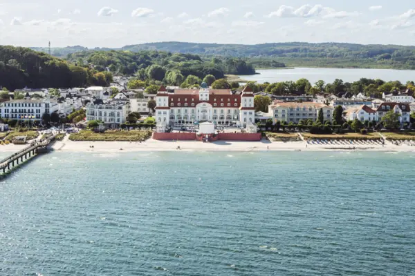 A view of the bell tower of the Kurhaus Binz, with the blue Baltic Sea stretching out behind it.