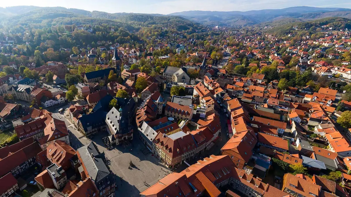 Luftaufnahme einer Stadt mit Häusern, Bäumen und Himmel im Hintergrund.