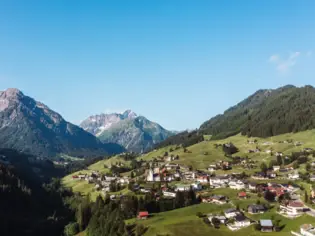 Small town in a green valley with a mountain backdrop.