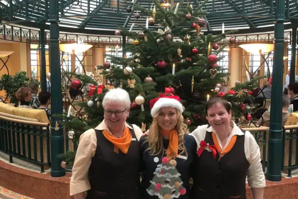 Eine Gruppe von Frauen posiert vor einem Weihnachtsbaum.