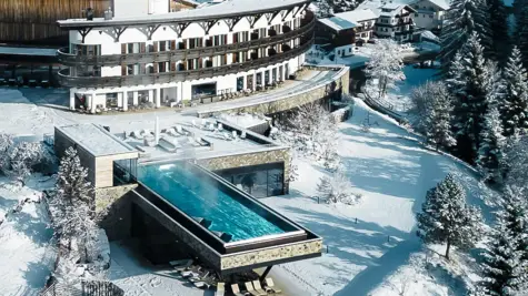 Gebäude mit einem Infinity-Pool umgeben von Schnee.