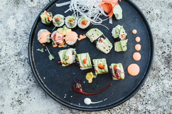 Ein Teller Sushi auf einer Steinoberfläche.