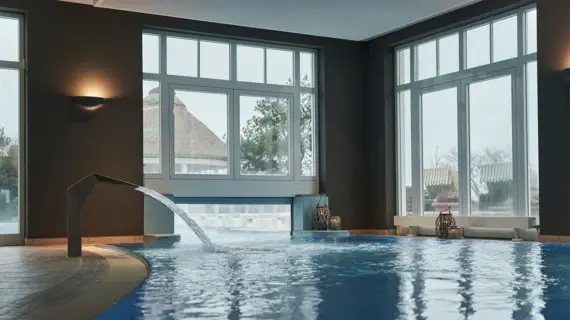Ein Innenpool mit Wasserdusche und einer Anbindung an den Außenpool.