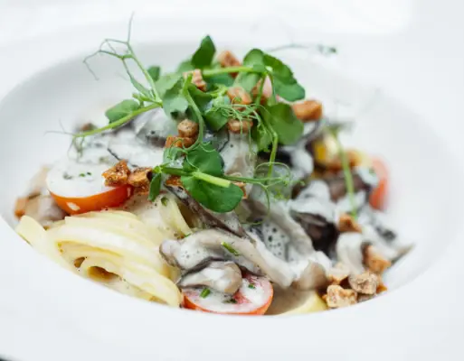 Ein Teller mit Pasta, Gemüse und Sauce.