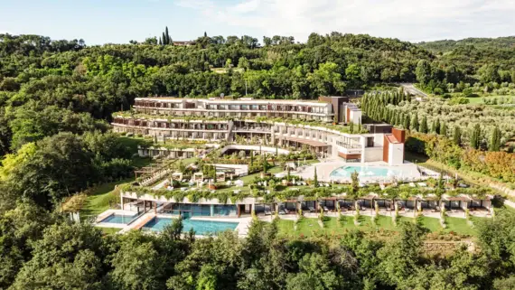 Luftaufnahme eines Resorts umgeben von üppiger Vegetation, Bäumen und Grasflächen.