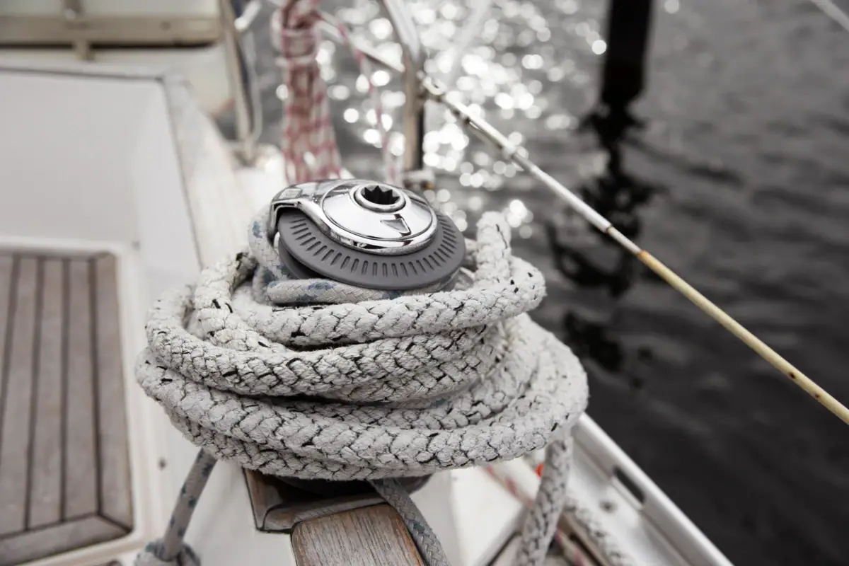 Detailaufnahme von einem Segelboot, bei der ein Tau um etwas gewickelt ist.