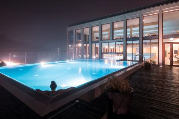 Donna in una piscina termale all'aperto di notte.