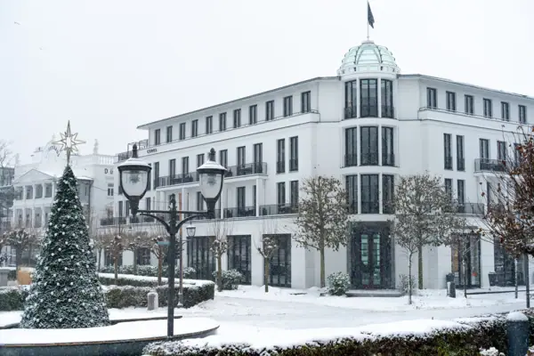 Ein Gebäude mit einer Fahne auf dem Dach und Bäumen davor.