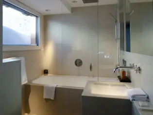 A bathroom with beige tiles and a bathtub.