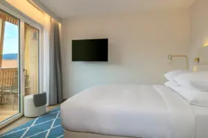 Schlafbereich Bett mit Flachbildfernseher an der Wand in einem stilvollen Zimmer.
