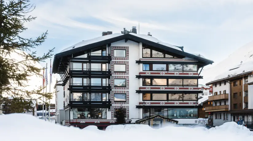 Das A-ROSA Collection Hotel Thurnher's Alpenhof umgeben von Schnee mit Bäumen im Hintergrund.