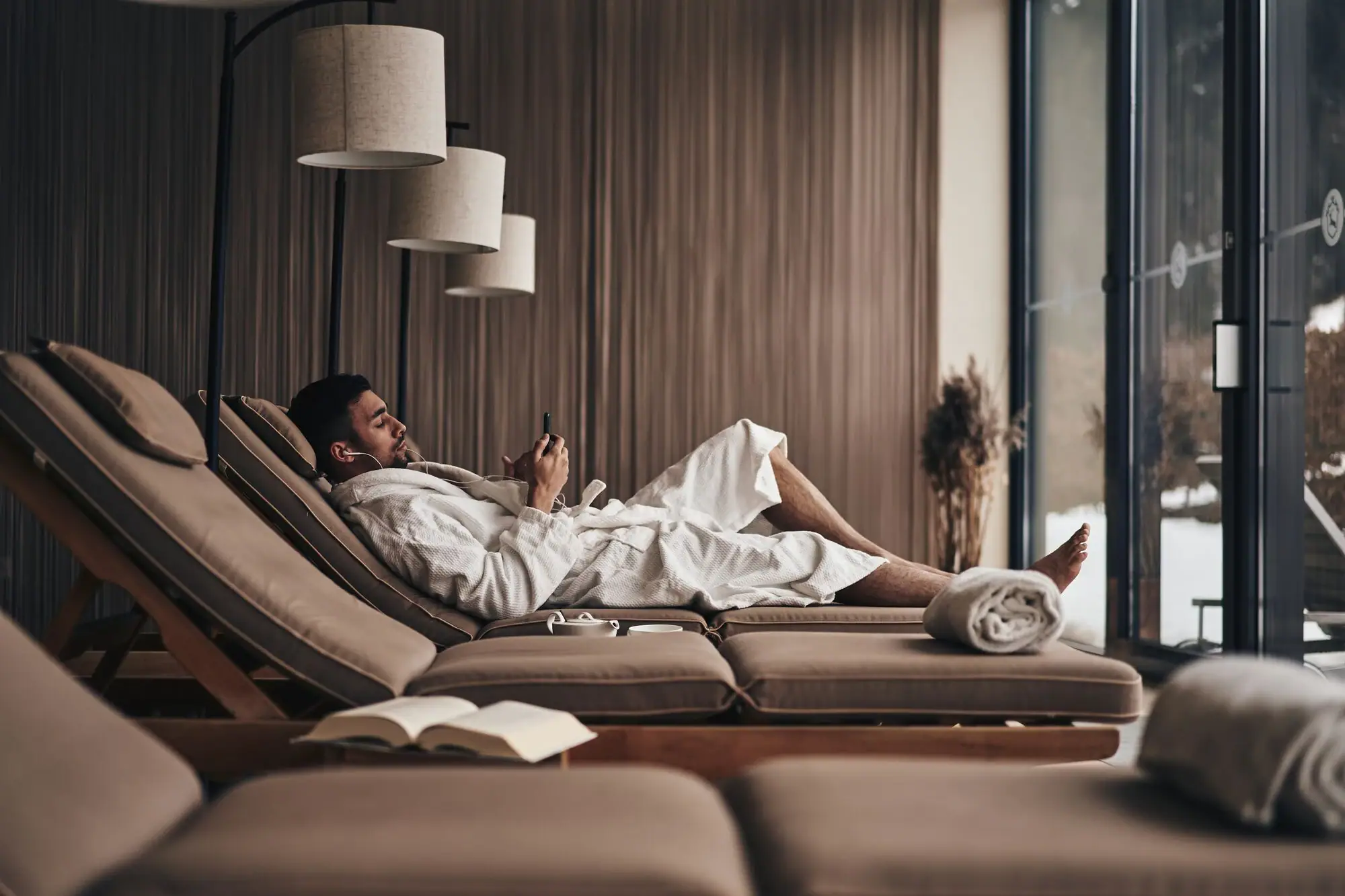 Ein Mann im Bademantel liegt auf einer Couch.