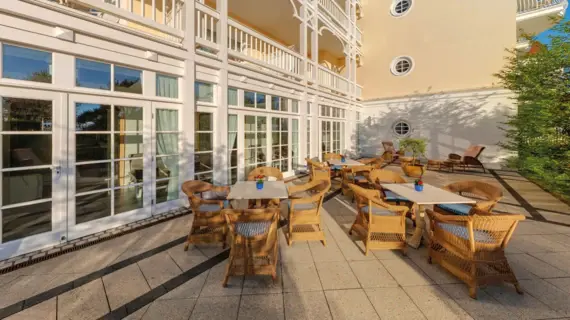 Eine Terrasse mit Stühlen und Tischen vor einem Gebäude.