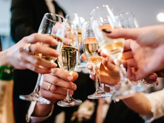 A group of people toast with champagne glasses.