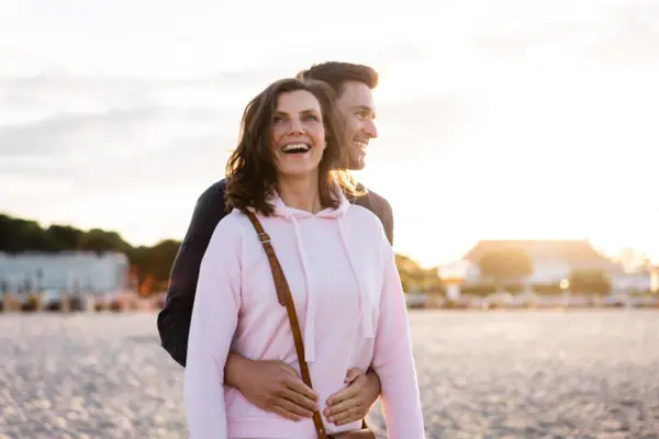 Ein Mann und eine Frau stehen am Strand.
