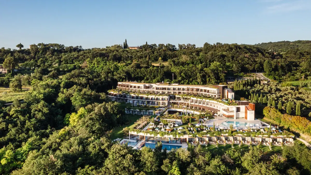A-ROSA Hotel am Gardasee Das Gebäude vom A-ROSA Gardasee als Drohnenaufnahme von weiter oben mit den drei Außenpools, umgeben von Bäumen.