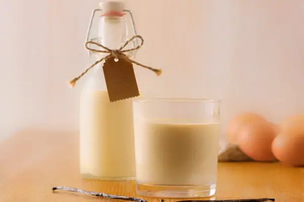 Eine Flasche und ein Glas Milch auf einem Tisch.