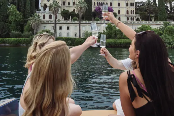 Eine Gruppe von Frauen hält Gläser vor einem See.