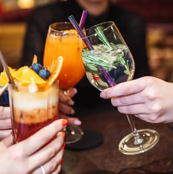 Ein kunstvoll dekorierter Cocktail steht auf einem Bartresen.