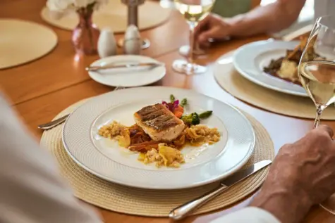 Ein Teller mit Essen und Weingläsern auf einem Tisch.