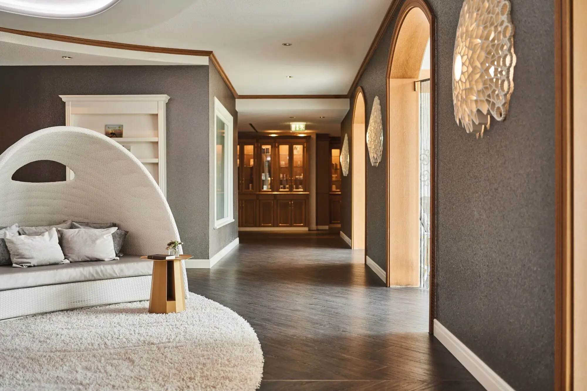 Der Eingang zum Spa Bereich im Kurhaus Binz mit weißem Teppich und rundem Stuhl.