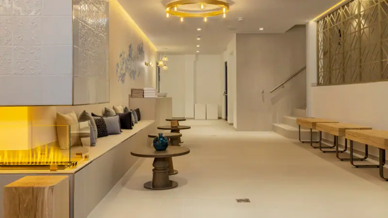 spa lobby Ein Raum mit einer Bank und Tischen.