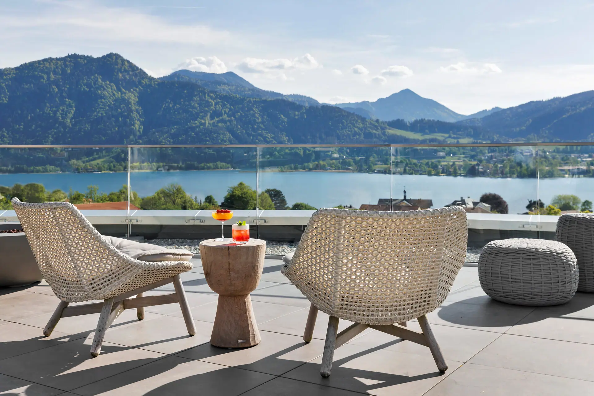 Ein Tisch und Stühle auf einer Terrasse mit Blick auf einen See.