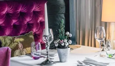A laid table with glasses, cutlery and decoration.