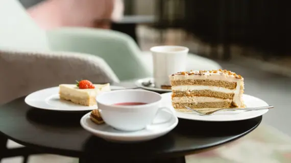 Ein Teller mit Kuchen und eine Tasse Tee auf einem Tisch.