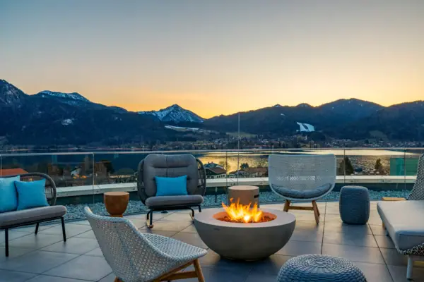 A-ROSA Tegernsee NIBar Feuerstelle mit Stühlen und Blick auf Berge im Hintergrund