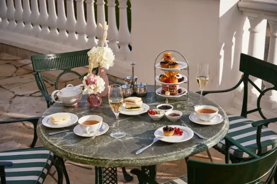 Ein gedeckter Tisch mit verschiedenen Speisen bei einer Tea Time darauf.