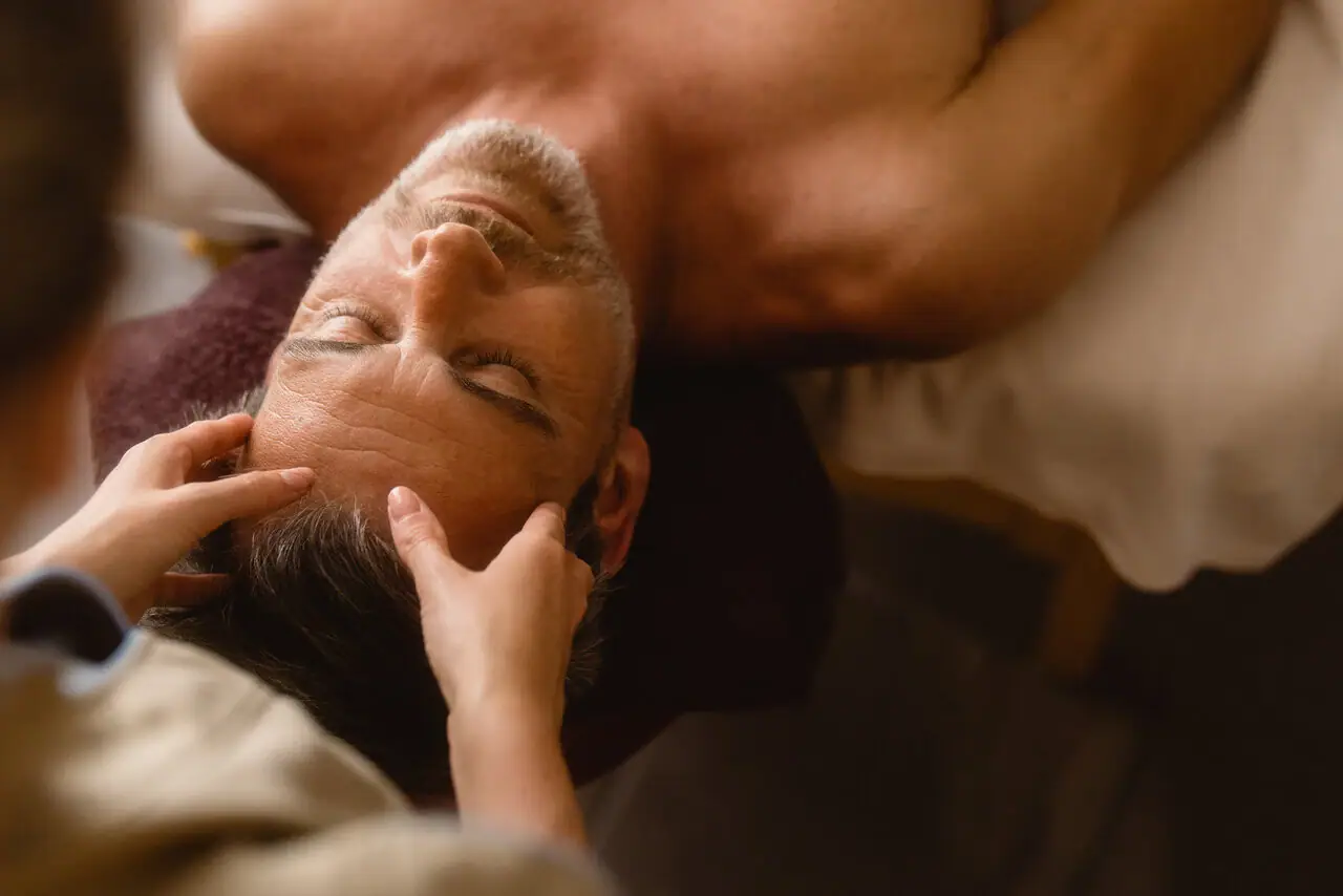 Massage Ein Mann liegt auf einem Massagetisch.