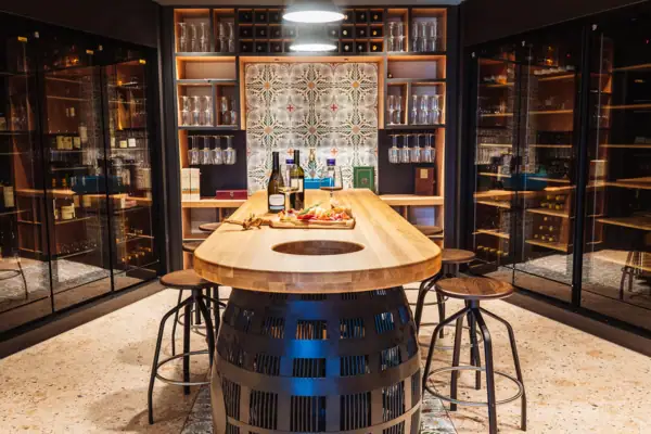 Ein Tisch mit Weinflaschen und kleinen Snacks darauf.