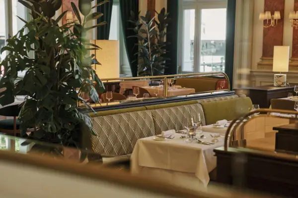 Ein Restaurant mit Tischen und Stühlen, im Hintergrund ein Weihnachtsbaum.