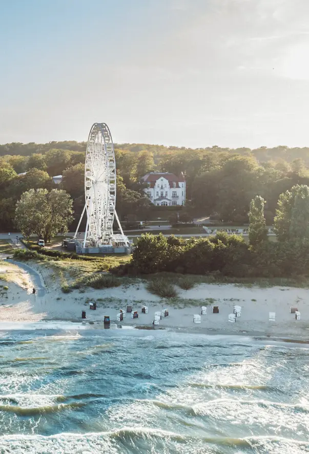 Strand mit einem Riesenrad und Bäumen.