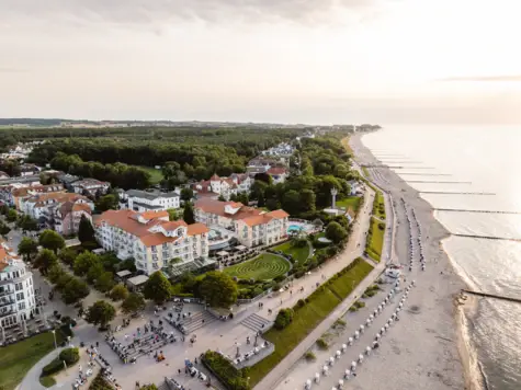 Luftaufnahme eines Strandes mit Gebäuden und Bäumen.