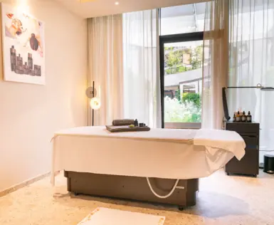 Un lettino da massaggio in una sala trattamenti fresca ed elegante