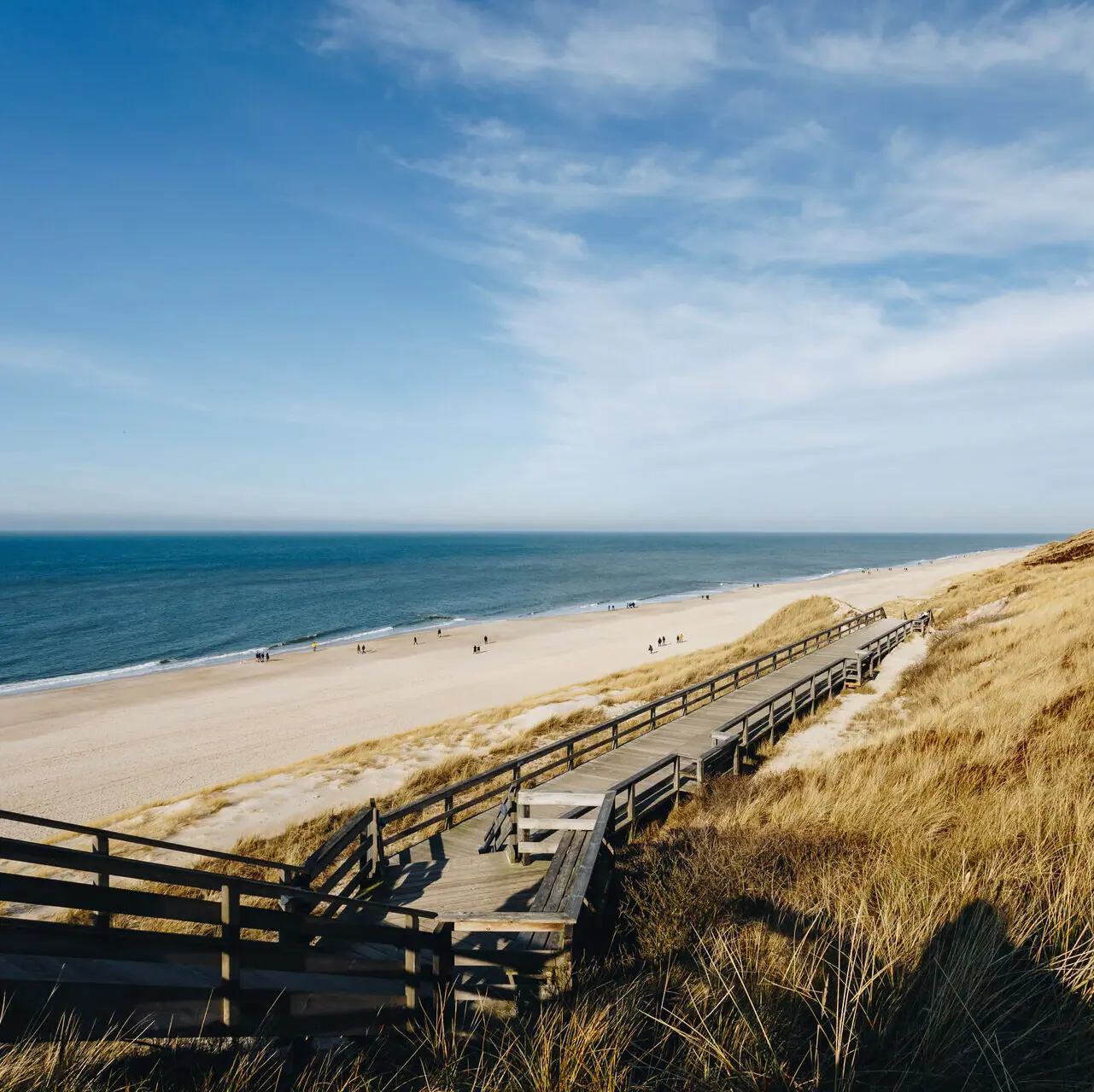 Ein Holzsteg führt zu einem Strand auf Sylt.