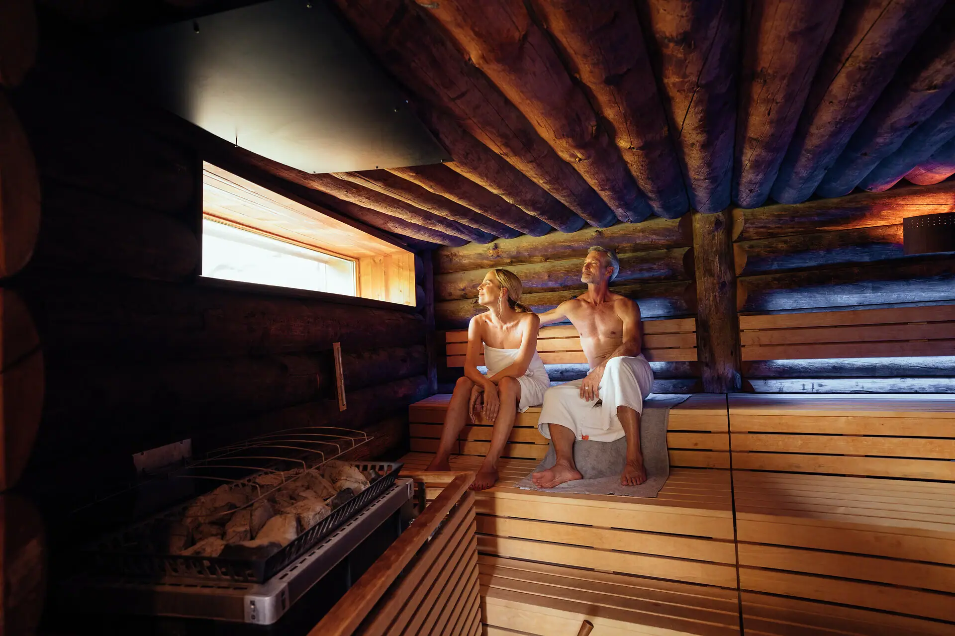 Ein Mann und eine Frau sitzen in einer Sauna.