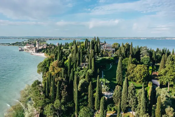 Große grüne Insel mit Bäumen und einem Gebäude in der Ferne.