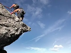 Person beim Klettern auf einem Felsen unter freiem Himmel.