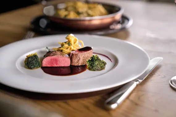 A plate of food on a table, garnished and served with cutlery.