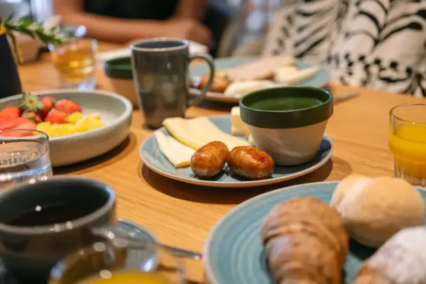 Ein Tisch mit Tellern voller Speisen und Kaffeetassen.