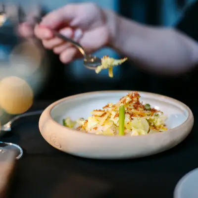 Abendessen Eine Person hält eine Gabel über einem Teller mit Essen.