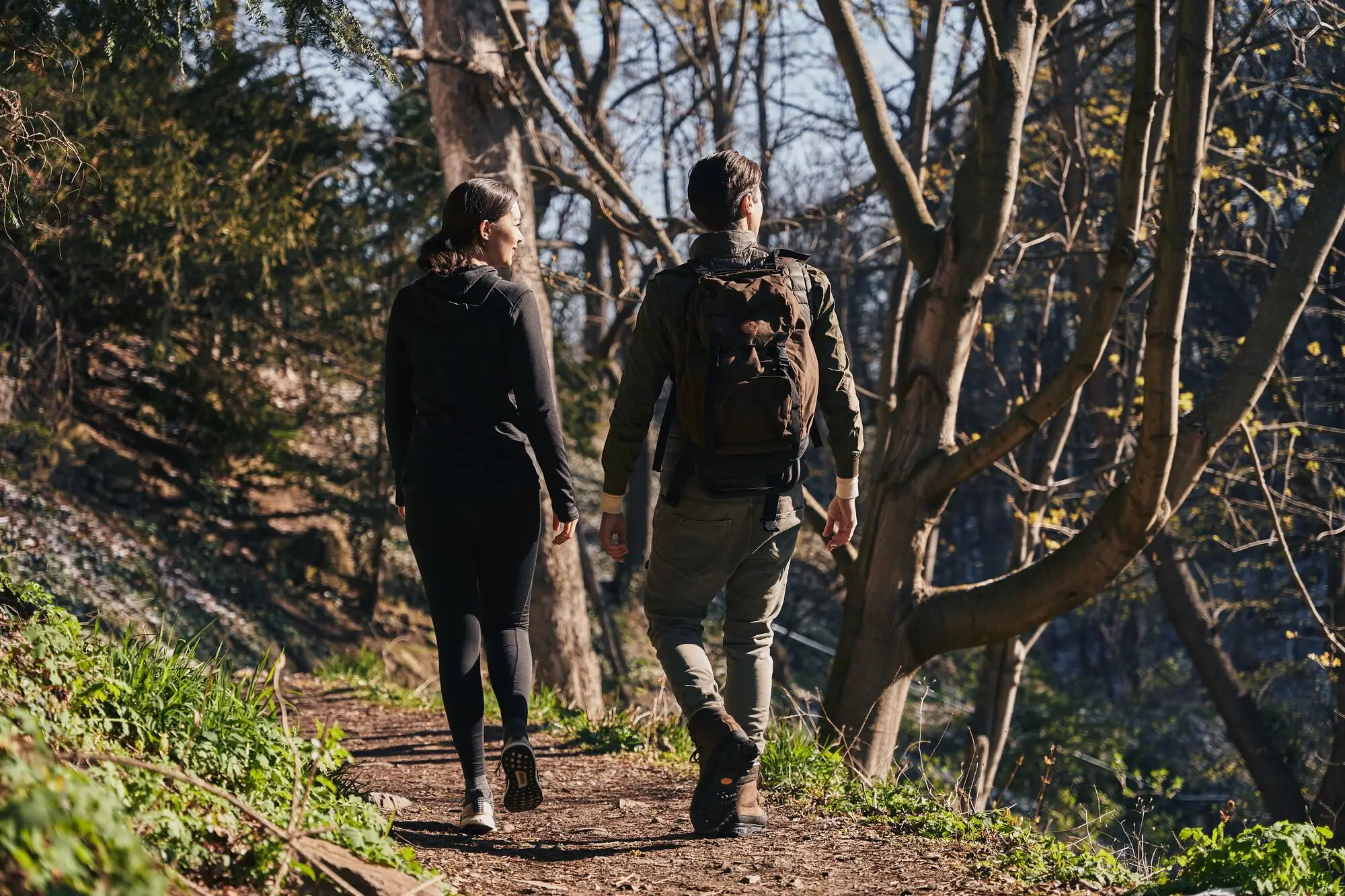Wanderung Ein Mann und eine Frau spazieren auf einem Waldweg.