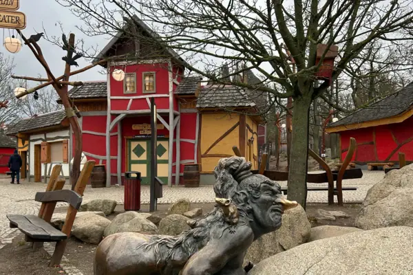 Statue einer Frau, die einen Felsen schiebt