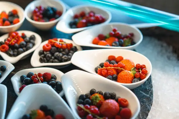 Eine Gruppe weißer Schalen mit verschiedenen Beeren.